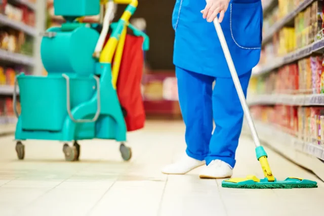 Eine Putzkraft bei der Ladenreinigung in einem Supermarkt