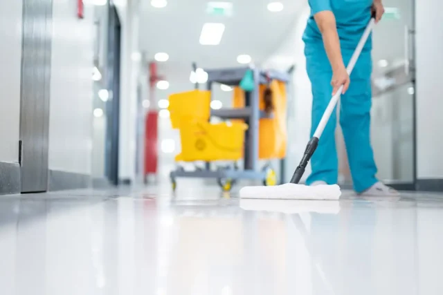 Eine Reinigungskraft bei der Unterhaltsreinigung in einem Gewerbegebäude
